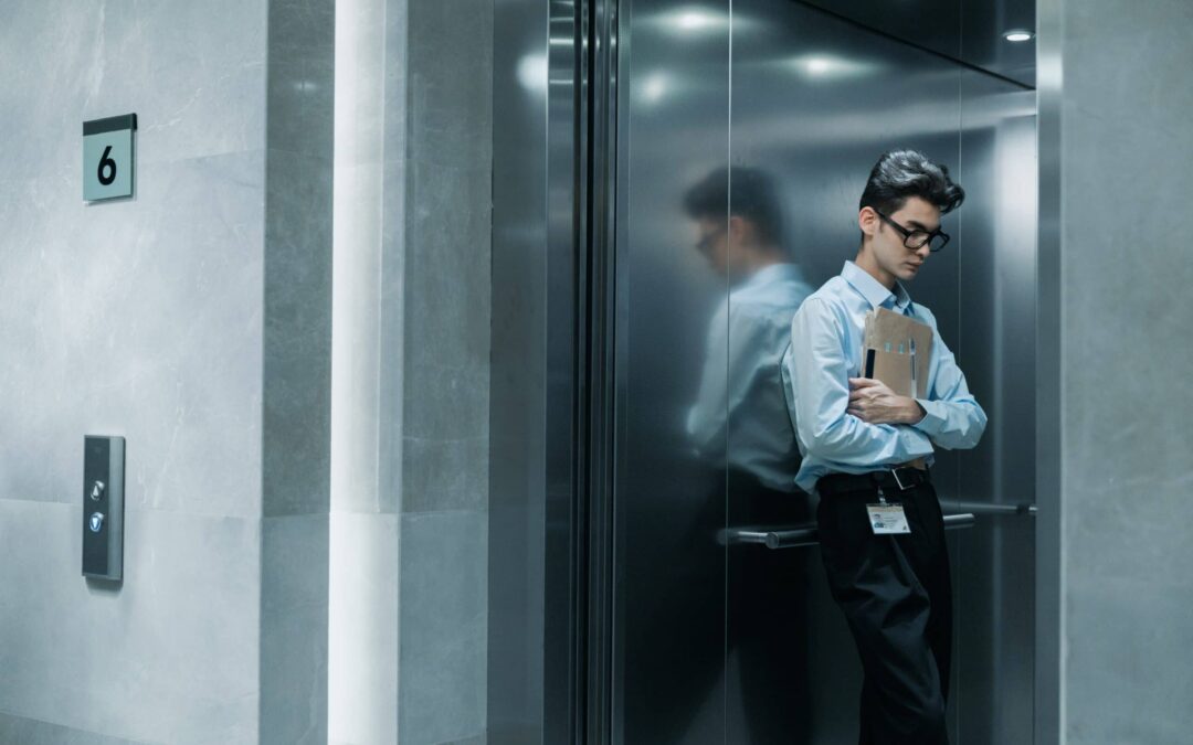 Man standing in elevator holding folders close to his chest