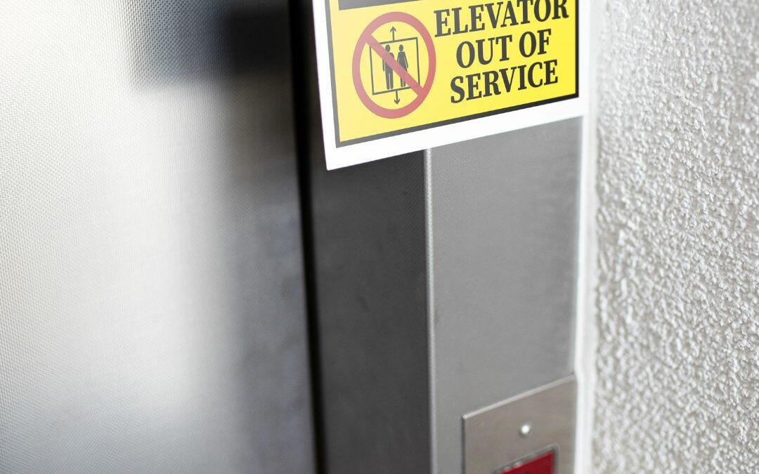 An "Out Of Service" sign hanging on the door of an elevator that overheated.