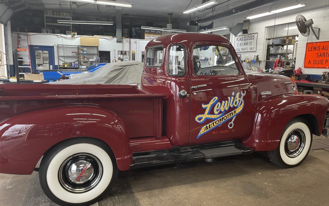 A classic truck with the Lewis Automotive logo on its door.